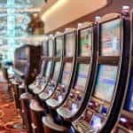 A row of slot machines in a brightly-lit casino.