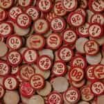 Painted red wooden bingo tiles spread across a flat surface.