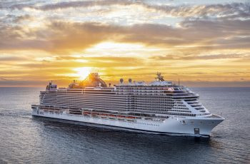 A massive cruise ship in the ocean pictured from above.